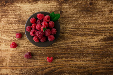 raspberries in bowl on wood  tableの写真素材