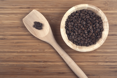 Coffee beans in bowl on wooden backgroundの写真素材