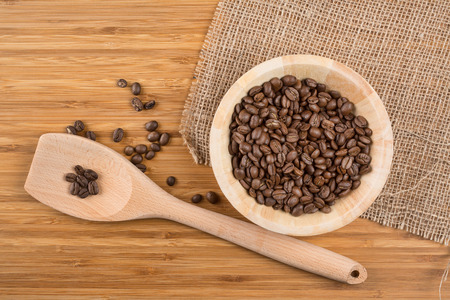 Coffee beans in bowl on wooden backgroundの写真素材