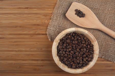 Coffee beans in bowl on wooden backgroundの写真素材