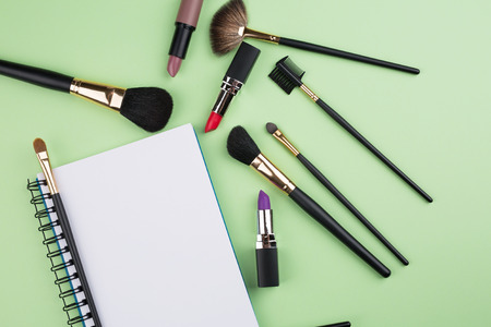 decorative cosmetics with notebook on green backgroundの写真素材