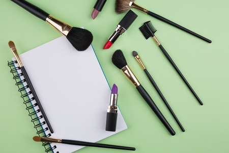 decorative cosmetics with notebook on green backgroundの写真素材