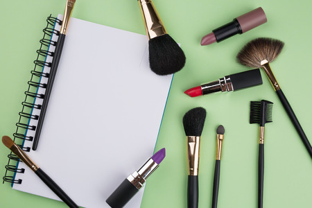 decorative cosmetics with notebook on green backgroundの写真素材