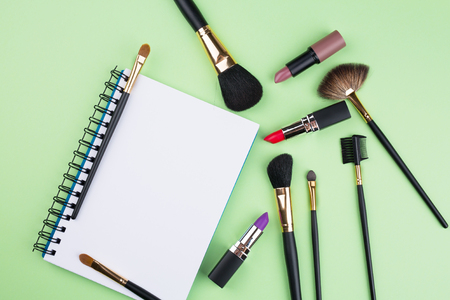 decorative cosmetics with notebook on green backgroundの写真素材