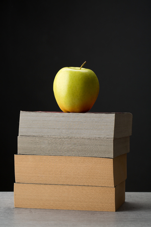 Stack of books with a red appleの写真素材