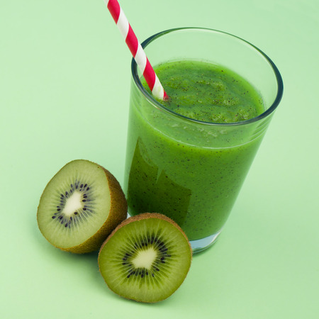 Fresh kiwi smoothie over green backgroundの写真素材