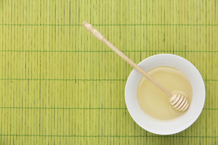   honey on a green bamboo tableの写真素材