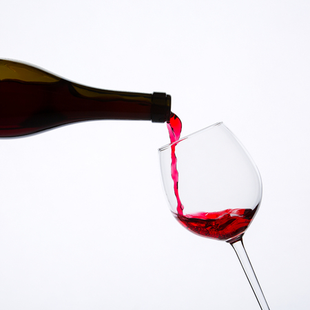 red wine pouring in glassの写真素材