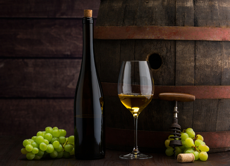 white wine bottle and wine glass on wodden barrelの写真素材