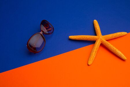 starfish and sunglass on blue and orange backgroundの写真素材
