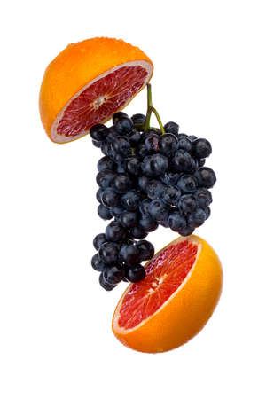 Dark blue grape with red grapefruit isolated on white backgroundの写真素材