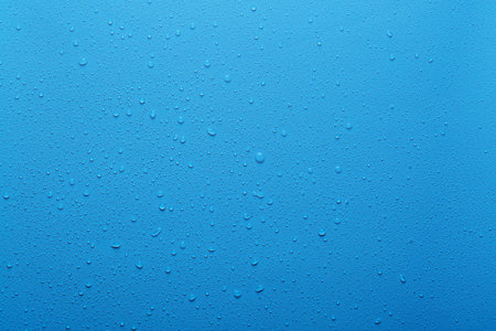 Water drops on blue background and plastic surfaceの写真素材