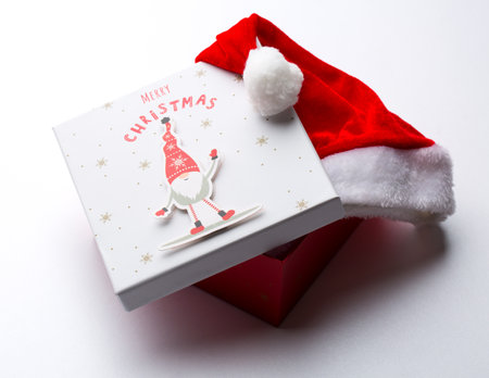 boxes with Christmas presents and santa hat on a wooden backgroundの写真素材