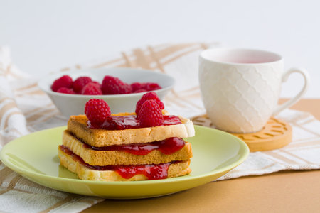 Toast with raspberry jam and cup of teaの写真素材