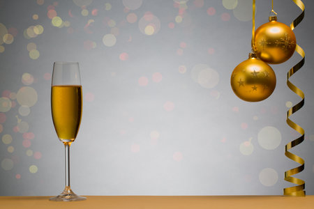 photo of two champagne glasses on brown table with Christmas ball, backgroundの写真素材