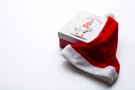 boxes with Christmas presents and santa hat on a wooden backgroundの写真素材