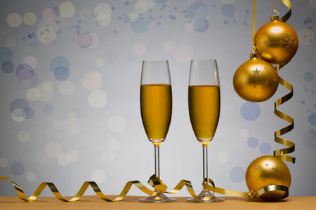 photo of two champagne glasses on brown table with Christmas ball, backgroundの写真素材