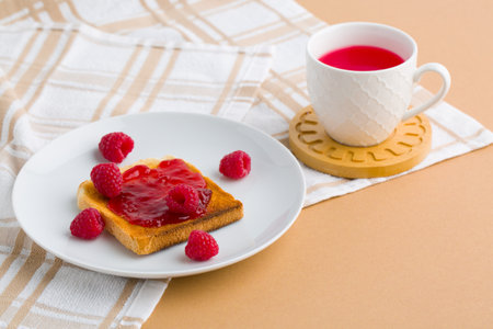 Toast with raspberry jam and cup of teaの写真素材