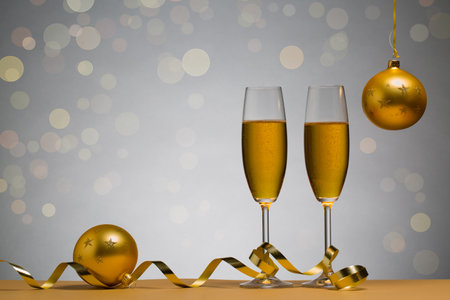 photo of two champagne glasses on brown table with Christmas ball, backgroundの写真素材