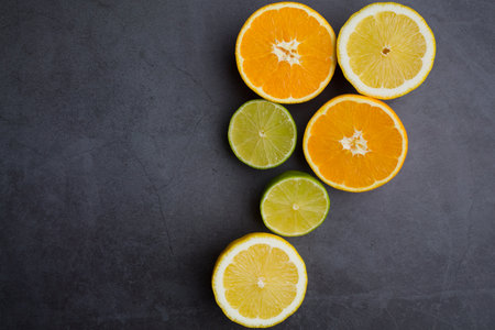 Fresh ripe citrus. Lemons, limes and oranges on dark stone background. Top view with copy spaceの写真素材