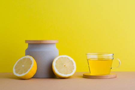 A front view of lemon decorated with tea in yellow backgroundの写真素材
