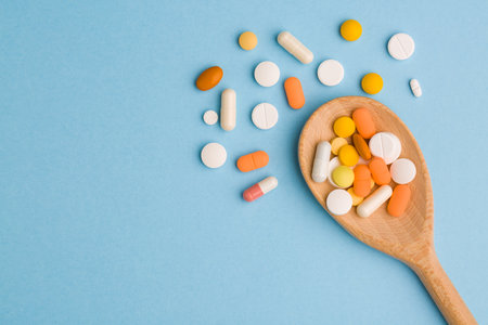 Assorted pharmaceutical medicine pills, tablets and capsules on blue background. Copy space for textの写真素材