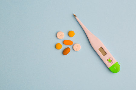 Blue background with pills and thermometer, flat lay. medical conceptの写真素材