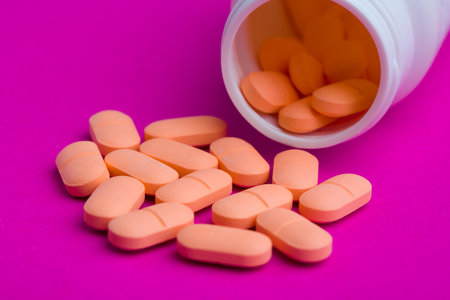 Assorted pharmaceutical medicine pills, tablets and capsules and bottle on magenta color background. Copy space for textの写真素材