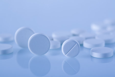 Macro shot of white medical pills on bright blue blurred backgroundの写真素材