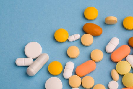 Assorted pharmaceutical medicine pills, tablets and capsules on blue background. Copy space for textの写真素材