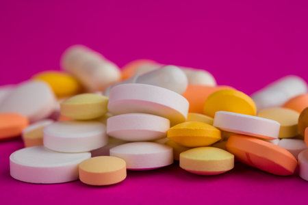 Assorted pharmaceutical medicine pills, tablets and capsules on magenta background. Copy space for textの写真素材