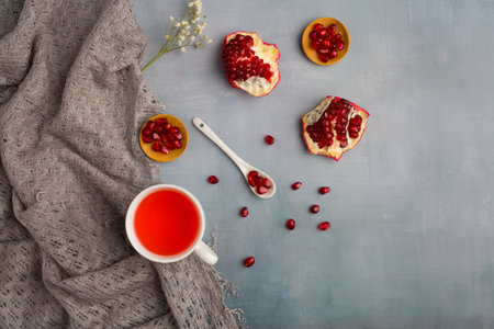 Cup of tea with pomegranate seeds on gray backgroundの写真素材