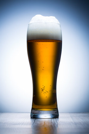glass of beer on a wooden table on a white background close upの写真素材