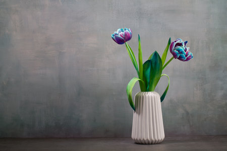 Beautiful tulips in vase on gray background with copy spaceの写真素材