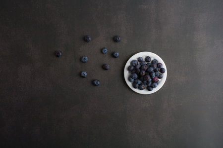 blueberryTop view of blueberries in a bowl on dark background with copy space.の写真素材