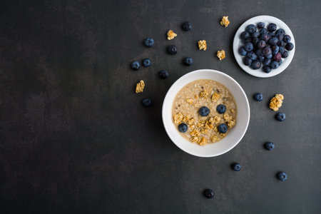 Delicious homemade granola in glass jar, fresh blueberries Healthy food sweet dessert snack. Diet nutrition concept. Vegetarian food. Flat lay. Top view.の写真素材
