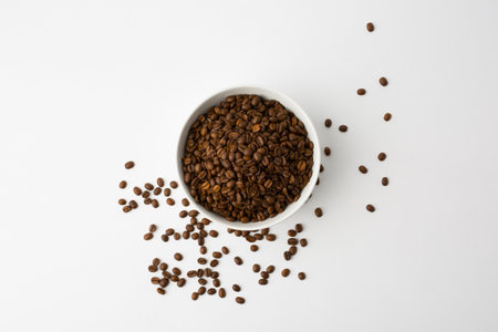 Coffee beans in the orange bowl. Top view. Isolated on white background. copy spaceの写真素材