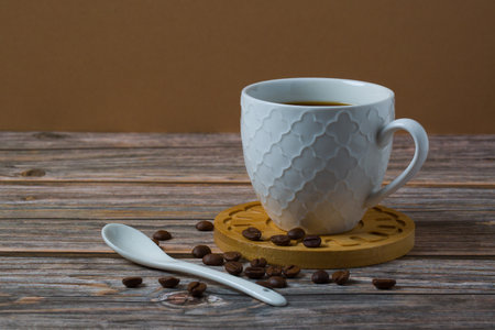 White espresso cup and coffee beans on wooden table background with copy space. Arabica grains, Coffee shop,の写真素材