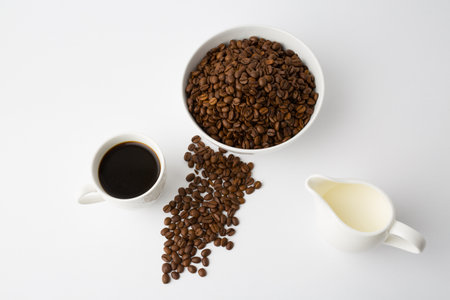 Coffee beans and a cup of coffee on a white backgroundの写真素材