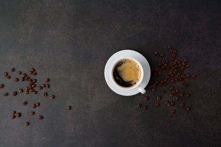 Coffee cup and coffee beans on dark background. Top view with copy spaceの写真素材