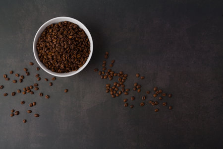 Coffee beans in a white bowl on a dark background.の写真素材