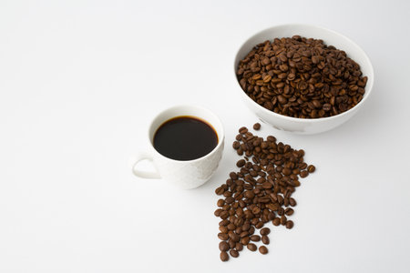 Coffee cup with roasted beans on white background. Top view with copy space for your textの写真素材