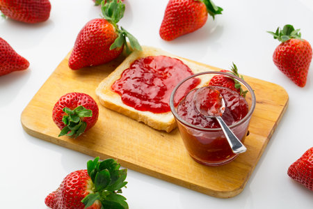 A bird's-eye view of the strawberry jam-filled bread and strawberry fruit on a white backgroundの写真素材
