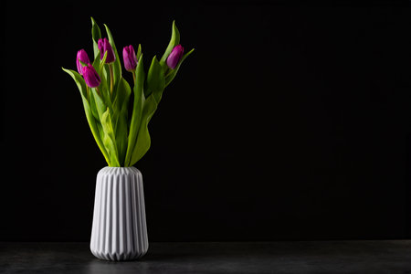 bouquet of tulips on a black background standing in a vaseの写真素材
