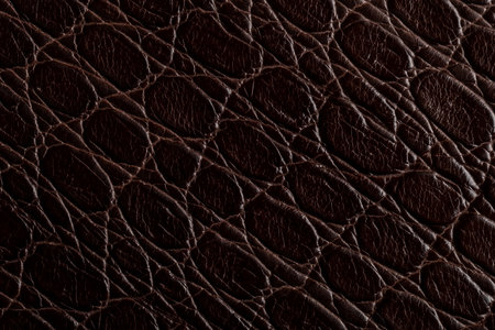 A close view shows the surface of brown leather, highlighting natural patterns and creases. The...