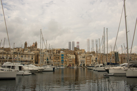 VITTORIOSA, MALTA - AUGUST 08, 2018: view of the Grand Harbor in Vittoriosa with boats and buildings on a cloudy day.のeditorial素材