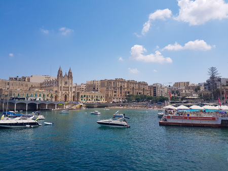 SLIEMA, MALTA - AUGUST 05, 2018: A port with many small boats and buildings on a summer day in Sliema, Malta.のeditorial素材