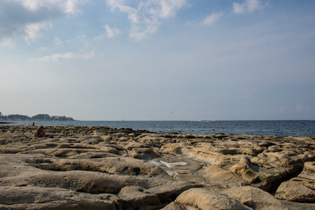 Rocky beach in Sliema with people relaxing on a summer day.のeditorial素材