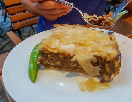 Fresh Romanian meat pie served in a white plate.の写真素材