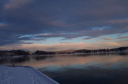 Landscape with snow-covered pier against the backdrop of sunsetの写真素材